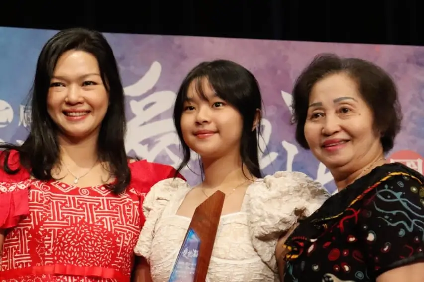 participant of Asia Aegean International Music Competition take a photo with her mother at the stage